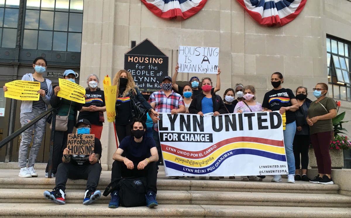 group in front of City Hall holding Lynn United for Change banner and protest signs related to housing including one that says Housing is a human right