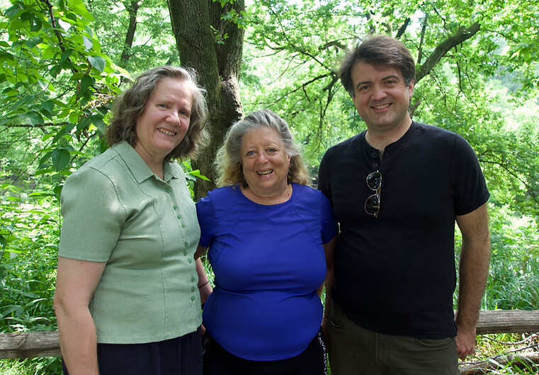 The three political candidates standding together, smiling in an outdoor setting.